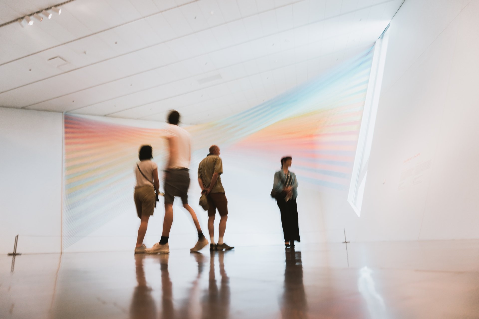 4 People standing and viewing art in a museum. Photo by Ian Dooley on Unsplash