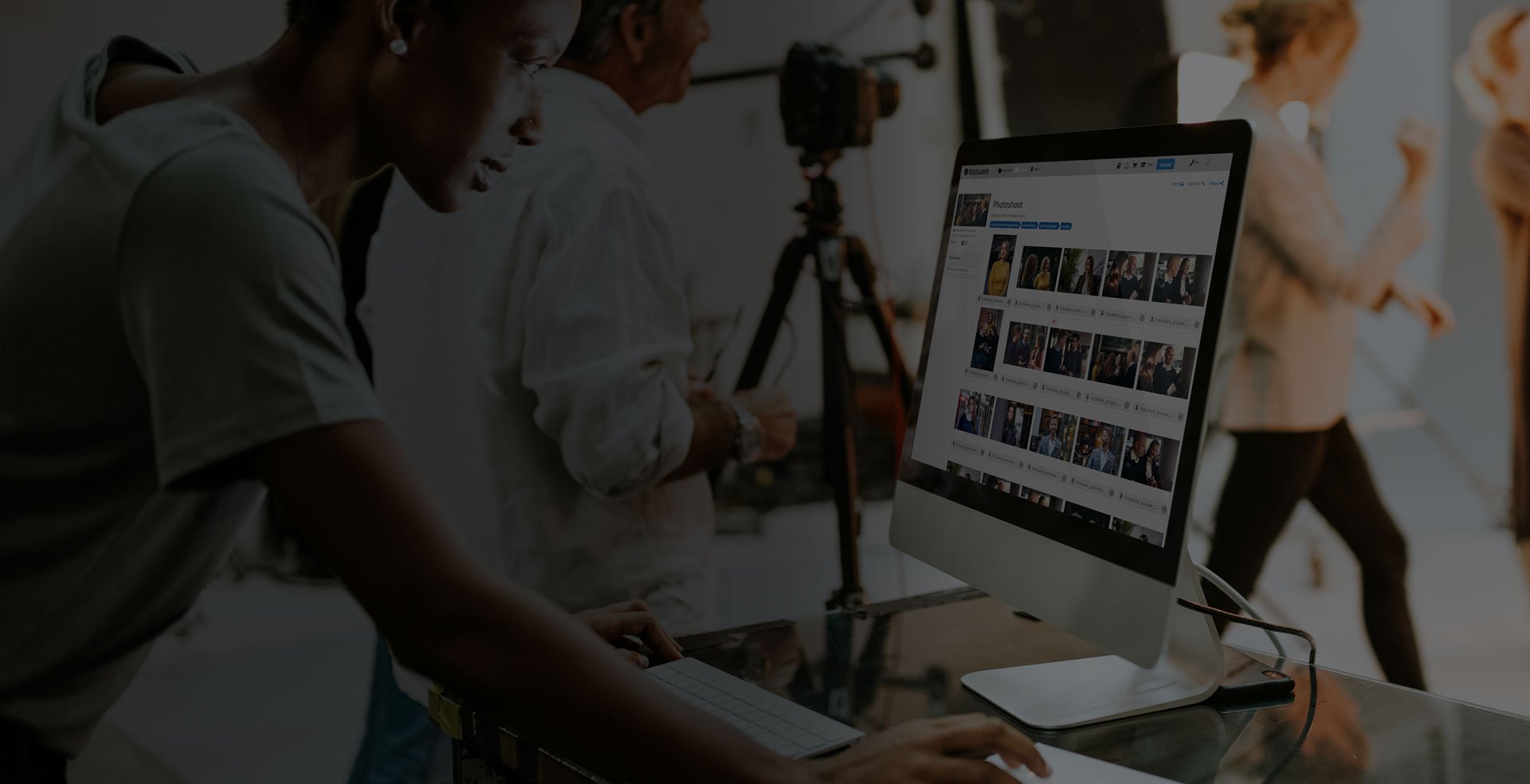 Photographer checkin images on a monitor showing FotoWare interface - while in a studio photoshoot
