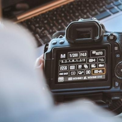 Someone holding a camera showing the back settings